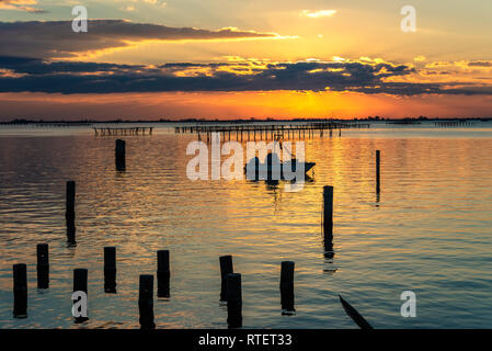 Tramonto su palafitta e reti da pesca lungo il Delta del Po. Italia Foto Stock