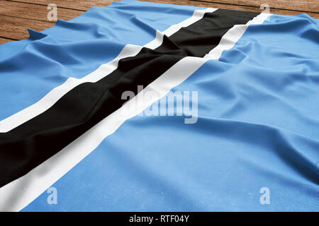 Bandiera del Botswana su una scrivania in legno sfondo. Seta flag Motswana vista dall'alto. Foto Stock