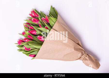 Bouquet di tulipani rosa giacente isolati su sfondo bianco carta Kraft Foto Stock