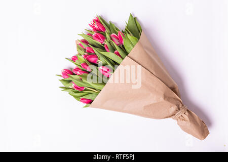 Bouquet di tulipani rosa giacente isolati su sfondo bianco carta Kraft Foto Stock