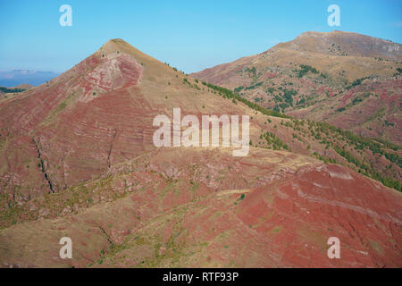 VISTA AEREA. Paesaggio insolito di roccia rossa nelle Alpi. Tête de Rigaud (a sinistra) e Dome de Barrot (a destra). Rigaud, Alpi Marittime, Francia. Foto Stock