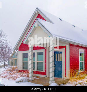 Bella casa con coperta di neve in cortile e tetto. Coloratissima casa di Alba, Utah con coperte di neve e tetto prato anteriore d'inverno. I pilastri a en Foto Stock