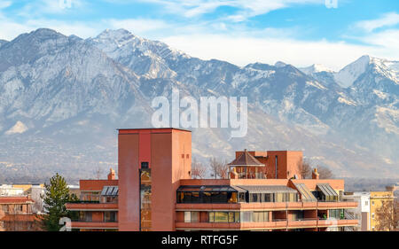 Edifici con Wasatch Mountain e il cielo dello sfondo. Edifici e alberi con neve spolverata di Wasatch Mountain in background. Paesaggio panoramico nel sale Foto Stock