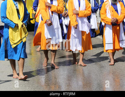 A piedi nudi la religione Sikh uomini durante la sfilata per le strade della città Foto Stock