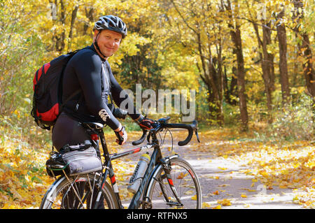 Regione di Kaliningrad, Russia, 13 ottobre 2018. Uomo con bicicletta nella foresta d'autunno. Foto Stock