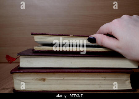 Pila di tre vecchi libri con copertina rigida Foto Stock