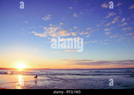 Un surfista silhouette al tramonto in Snapper Rocks, Australia Foto Stock