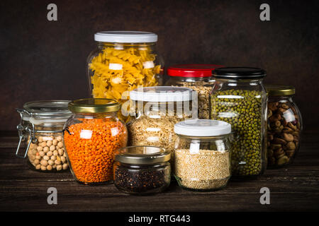 Cereali, legumi e fagioli in barattoli di vetro sul tavolo da cucina. Foto Stock