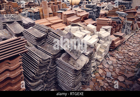 Una grande raccolta di diverse tegole del tetto, mattoni e comignoli in corrispondenza di un cantiere di recupero nel Regno Unito. Foto Stock