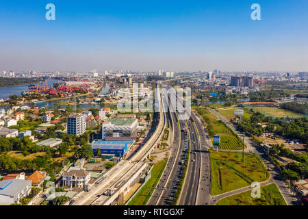 Vista superiore antenna di Ha Noi autostrada vista dal distretto 2 di district 9, Ho Chi Minh City con lo sviluppo di edifici, trasporti, infrastrutture, vie Foto Stock