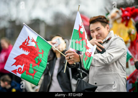 Welsh bandiere nazionali sono ondulata, durante un giorno di San Davide parata in Cardiff. Foto Stock