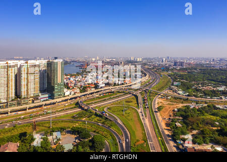 Vista superiore antenna di Ha Noi autostrada a district 9 e Cat Lai crocevia, Ho Chi Minh City con lo sviluppo di edifici, trasporto, Vietnam Foto Stock