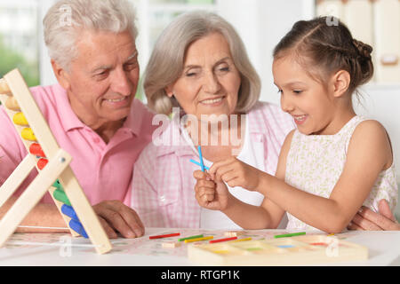 Ritratto di felice nonni con il nipote utilizzando abacus insieme Foto Stock