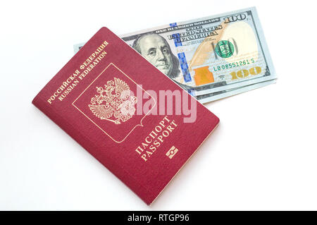 Due banconote di 100 dollari americani ciascuno, giacente nel passaporto russo su uno sfondo bianco. Foto Stock