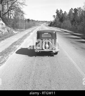 Stile di vita negli anni cinquanta. Una vecchia auto è la guida su una strada in primavera. Foto Kristoffersson Ref BV77-12. La Svezia 1952 Foto Stock