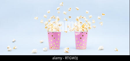 Flying Popcorn in un luminoso e di vetro su uno sfondo blu. Copia banner di spazio Foto Stock
