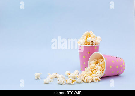 Due tazze di gustoso popcorn su uno sfondo blu spazio copia Foto Stock