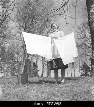 Facendo la biancheria negli anni cinquanta. Una signora è fuori in giardino di riagganciare il servizio lavanderia a secco. Foto Kristoffersson ref BC7-8. La Svezia 1951 Foto Stock