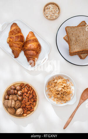 La salute e la colazione colorata - cialde, muffin, mandorle, nocciole, vari tipi di frutta fresca sul tavolo. Health food concept .vista dall'alto. Foto Stock