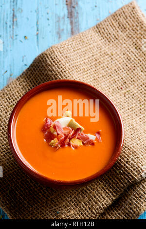 Elevato angolo di visione di un vaso di terracotta con lo spagnolo salmorejo cordobes o porra antequerana, una fredda zuppa di pomodoro condito con prosciutto Serrano e crostini, Foto Stock