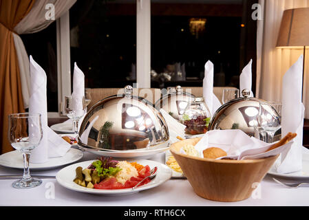 Servita la cena table.piatto caldo sulla cupola il vassoio sulla tavola server. Foto Stock