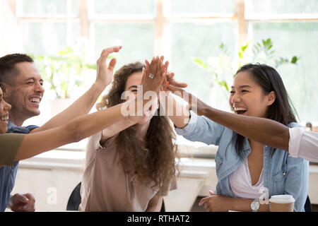 Felice african asian caucasian business team di persone dare alta cinque Foto Stock