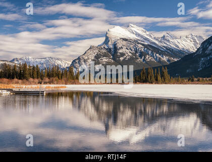 Sunrise a Vermiglio laghi vicino a Banff, Alberta, Canada con le montagne circostanti si riflette nel ghiaccio e acqua. Foto Stock