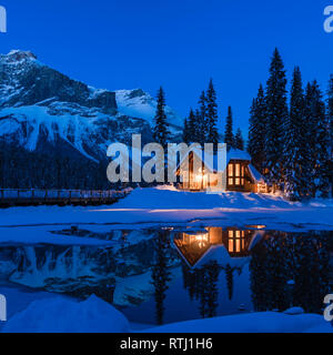 Lodge e montagne coperte di neve si riflette nel Lago Smeraldo durante ore blu dopo il tramonto, Parco Nazionale di Yoho, British Columbia, rocce canadesi, Canada Foto Stock