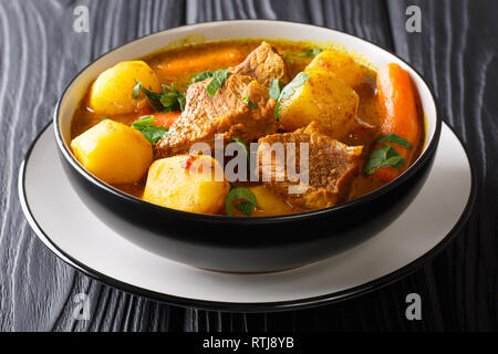 Tradizionale Africana di slow stufato di agnello con spezie e verdure close-up in una ciotola sul tavolo orizzontale. Foto Stock