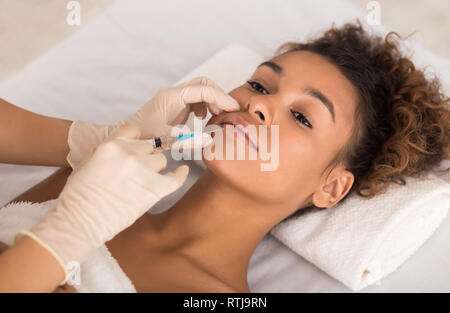 Lip augmentation. Giovane donna riceve iniezione di acido Foto Stock