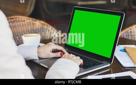 La millenaria donna che lavorano su computer portatile con vuoto schermo verde Foto Stock