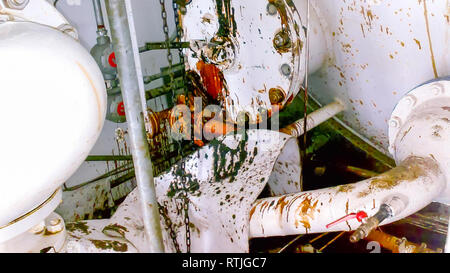 Il pavimento dell'unità di controllo del dispositivo è un hitter-tritter riempito con olio. I lavori di riparazione. Apertura delle apparecchiature. Pulizia del galleggiante di livello Foto Stock