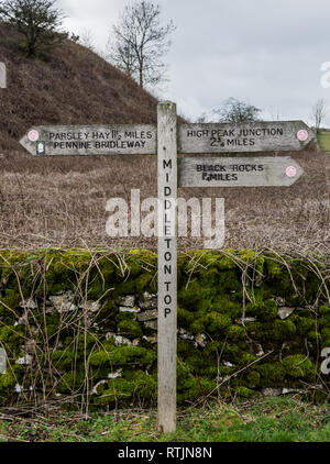 Un segno posto a Middleton Top nel Derbyshire Peak District. Il segno indica le direzioni di prezzemolo fieno, elevati picchi di giunzione e rocce nere. Foto Stock