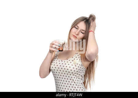 Bella donna con gli occhi chiusi tiene un bicchiere di medicina, stringendo la sua testa, isolati su sfondo bianco Foto Stock