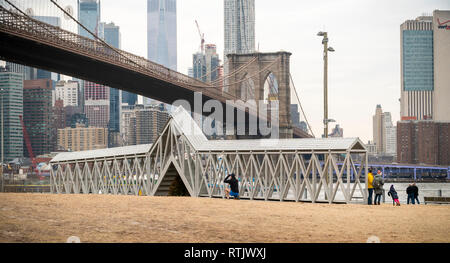 Siah Armajani esperienziale dell arte pubblica scultura, 'Ponte sull albero " è molto apprezzato dai visitatori al Ponte di Brooklyn Park, tra Manhattan e di ponti di Brooklyn a New York sabato 23 febbraio, 2019. Il 91-piede lungo pezzo con scale nel centro solleva il partecipante su una solitaria albero sempreverde ed è la prima volta che il 1970 pezzo è stato visualizzato in quasi cinquant'anni. Il Met Breuer ospita una retrospettiva di Minneapolis in base degli artisti e opere "Ponte sull albero " sarà sul display nel parco fino al 29 settembre. (Â© Richard B. Levine) Foto Stock