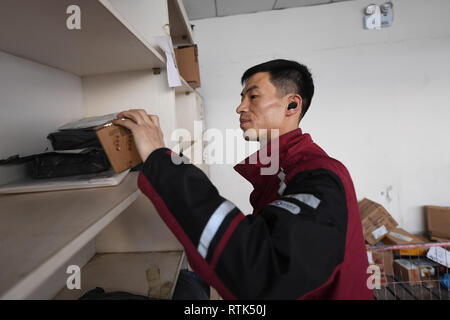 Shanxi cinese nella provincia di Shanxi. 28 Feb, 2019. Liu Wenyu ordina i pacchi in corrispondenza di una stazione di corriere di YTO Express Xiaodian nel distretto di Taiyuan, nel nord della Cina di nella provincia di Shanxi, 28 febbraio, 2019. Liu ha perso il suo braccio destro da incidente quando era 21. Nonostante il difetto fisico, Liu ha rifiutato di essere sconfitta da lavorare come un esperto deliveryman con la sua forte volontà e sincerità. Liu è stato promosso come un manager di un corriere dalla stazione di Taiyuan, e la sua storia è stata riportata da un programma TV in 2017. Credito: Yang Chenguang/Xinhua/Alamy Live News Foto Stock