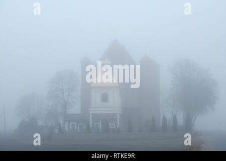 Vista su un nebbioso giorno del XVI secolo chiesa ortodossa orientale di San Michele Edificata nel bielorusso Architettura gotica nella periferia nord del villaggio di Synkavichy, nel quartiere Zelva, Provincia di Hrodna in Bielorussia. Foto Stock