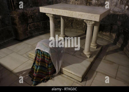 Pellegrino cristiano dall Africa inginocchiato in preghiera presso la cappella Greca di San Longino il centurione romano che hanno trafitto di Cristo e convertito al cristianesimo all interno della chiesa del Santo Sepolcro la Città Vecchia di Gerusalemme Est Israele Foto Stock