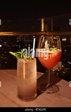 Vista frontale di due bicchieri di cocktail al bar sul tetto la terrazza su un estate tropicale di notte Foto Stock