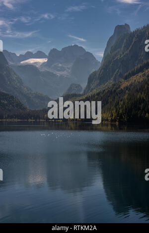 D'autunno bella vista sul lago Gosausee e monti Dachstein con grande ghiacciaio Gosau riflessa nell'acqua. Patrimonio Mondiale dell'UNESCO. Ubicazione Posto Foto Stock