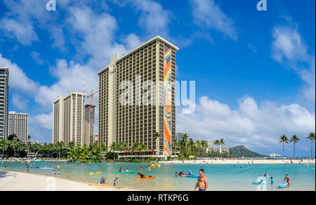Gli amanti del sole sulla spiaggia di Waikiki all'Hilton Hawaiian il 7 agosto 2016 a Honolulu, Stati Uniti d'America. La spiaggia di Waikiki si trova quartiere di Honolulu, meglio conosciuta per il bianco Foto Stock