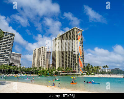 Gli amanti del sole sulla spiaggia di Waikiki all'Hilton Hawaiian il 7 agosto 2016 a Honolulu, Stati Uniti d'America. La spiaggia di Waikiki si trova quartiere di Honolulu, meglio conosciuta per il bianco Foto Stock