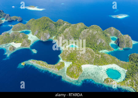 Vista aerea di una remota insieme di isole, circondato da una bellissima barriera corallina, Raja Ampat isole, Papua occidentale, in Indonesia, Oceano Pacifico Foto Stock