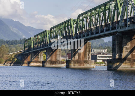 Un livello di acqua vista di una lunga linea di treno auto attraversando Burrard ingresso sulla seconda si restringe il ponte ferroviario, muovendo dalla North Shore a Vancouver. Foto Stock