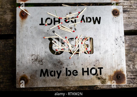 Guardando verso il basso in corrispondenza di una piastra riscaldante per barbecue con una scatola di fiammiferi versato giacente sulla parte superiore forestale scozzese Glen Nevis Fort William highlands scozzesi uk Foto Stock