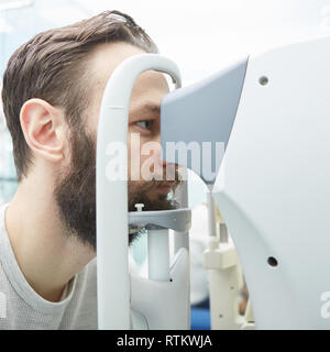 Bel giovane uomo è il controllo della visione nella moderna Oftalmologia Clinica. Paziente in Oftalmologia Clinica. Foto Stock