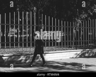 Barcellona, Spagna - Nov 12, 2017: pensieroso donna a piedi vicino al Parc de la Ciutadella recinti protettivi Foto Stock