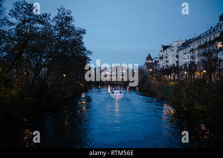 Imbarcazione turistica al tramonto sul fiume Ill a Strasburgo, Alsazia, Francia Foto Stock