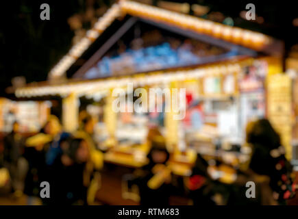 Illuminata fiera di Natale chiosco di stallo di mercato con carichi di deliziosi biscotti, dolci e i bambini a mangiare nelle vicinanze Foto Stock