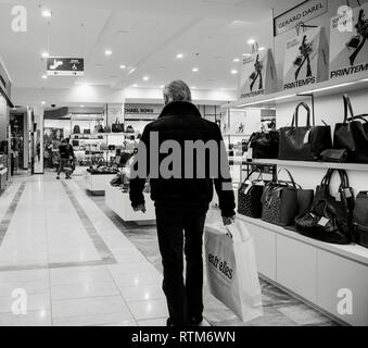 Strasburgo, Francia - 11 GEN 2018: vista posteriore della moda maschile senior a piedi nella Printemps Luxury department store durante la stagione delle vendite ammirando la femmina borse in pelle Foto Stock